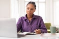 Focused african american female teen student studying with laptop and notebook Royalty Free Stock Photo