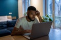 Focused African American guy freelancer working on laptop at home office, feeling overwhelmed Royalty Free Stock Photo