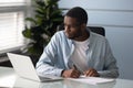 Focused african American man make notes watching webinar on laptop Royalty Free Stock Photo