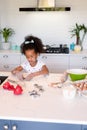 Focused african american messy girl baking in kitchen