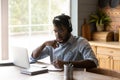 Focused African American student guy in headphones watching learning webinar Royalty Free Stock Photo