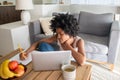 Focused African American woman using laptop, working from home Royalty Free Stock Photo