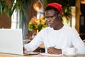 Concentration black hipster male in headphones, eyewear studing or working remotely on computer Royalty Free Stock Photo