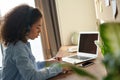 Focused african female student wear headphones elearning making notes. Royalty Free Stock Photo