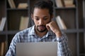 Focused Afro American adult student using laptop in library Royalty Free Stock Photo