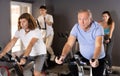 Aged man doing cardio workout on exercise bike in gym Royalty Free Stock Photo