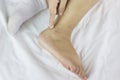 Focused at ankleand lotion on finger, women apply lotion on dried ankle, rough or not smoothankle,moisten dried ankle on bed