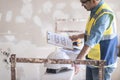 Focused architect holding clipboard with apartment drawing blueprint in hand