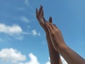 Focused and Artistic Hands with Blurred Blue Sky Background