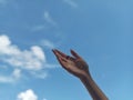 Focused and Artistic Hand with Blurred Blue Sky Background