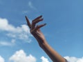 Focused and Artistic Right Hand with Blurred Blue Sky Background