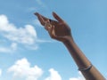 Focused and Artistic Right Hand with Blurred Blue Sky Background