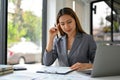 Focused Asian businesswoman analyzing financial data on reports at her desk Royalty Free Stock Photo