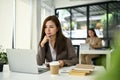 Focused Asian businesswoman looking at her laptop screen, pensive thinking a plan Royalty Free Stock Photo