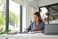 Focused Asian businesswoman working on accounting and sales report at her desk Royalty Free Stock Photo