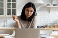 Focused Asian woman in headphones watching webinar, using laptop Royalty Free Stock Photo