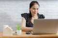 Focused Asian woman using laptop at home, looking at screen, chatting, reading or writing email Royalty Free Stock Photo