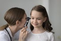 Focused attentive kids otolaryngologist examining girls ear for infection