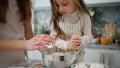 Focused baby mixing whisk at kitchen closeup. Smiling mother helping to daughter Royalty Free Stock Photo