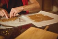 Home Baker Rolls And Cuts Dough On Parchment, Creating Small Rectangular Pieces For Baking In Warm Kitchen Royalty Free Stock Photo