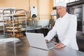 Focused baker using laptop on worktop