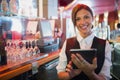 Focused barmaid using touchscreen till