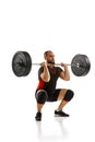 Focused bearded man, athlete with strong body training, lifting heavy weights, barbell against white background Royalty Free Stock Photo