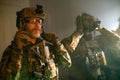 Focused bearded men in military equipment in dark room Royalty Free Stock Photo