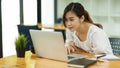 Focused beautiful asian woman using laptop, look at laptop screen, reading email