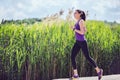 Focused beautiful woman running on sunny day on nautre background. Sport