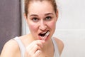 Focused beautiful young woman brushing her teeth with care