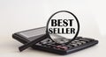 Focused on BEST SELLER concept. Magnifier glass with text on calculator. Business concept Royalty Free Stock Photo