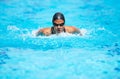 Focused on bettering her time. Determined young female swimmer swimming within her lane in a pool.