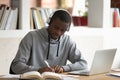 Focused biracial guy writing studying using laptop Royalty Free Stock Photo
