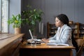 Focused black female remote bookkeeper preparing financial report on laptop while working from home Royalty Free Stock Photo