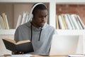 Focused black male student studying at laptop at home