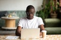 Focused black man studying on laptop drinking coffee Royalty Free Stock Photo