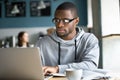 Focused black student studying online in coffeeshop