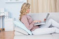 Focused blonde on couch using laptop