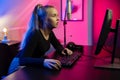 Focused Blonde E-sport Gamer Girl with Headset Playing Online Video Game on PC Royalty Free Stock Photo