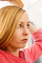 Focused blonde woman brushing her hair