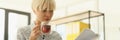 Focused blonde woman drinks aromatic tea reading papers