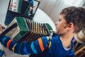 Boy playing accordion and watching online course on laptop while practicing at home. Online training, online classes Royalty Free Stock Photo