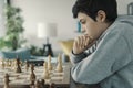 Focused boy playing chess at home Royalty Free Stock Photo