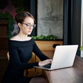 Focused business woman sit on cafe working on laptop, concentrated serious female working with computer and notebook in coffee sho Royalty Free Stock Photo