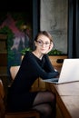 Focused business woman sit on cafe working on laptop, concentrated serious female working with computer and notebook in coffee sho Royalty Free Stock Photo