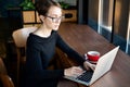 Focused business woman sit on cafe working on laptop, concentrated serious female working with computer and notebook in coffee sho Royalty Free Stock Photo