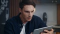 Focused businessman reading project results on tablet computer at home office. Royalty Free Stock Photo