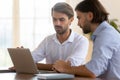 Focused businessman salesman consult male client show presentation on laptop