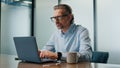 Focused businessman texting laptop at office closeup. Eyeglasses ceo man working